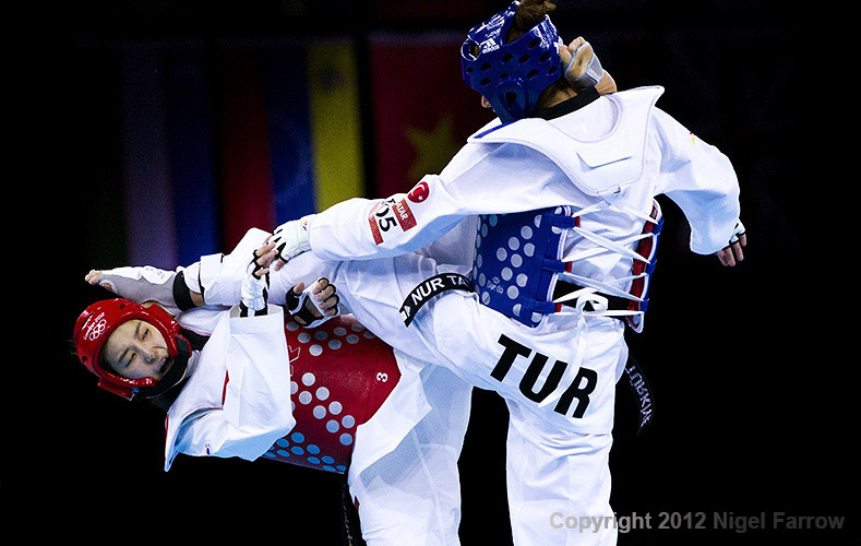 TAEKWONDO-Hwang Kyung-Seon (left) of South Korea and Nur Tatar (right) of Turkey both land kicks during the women's -67kg category final at the London 2012 Olympic Games